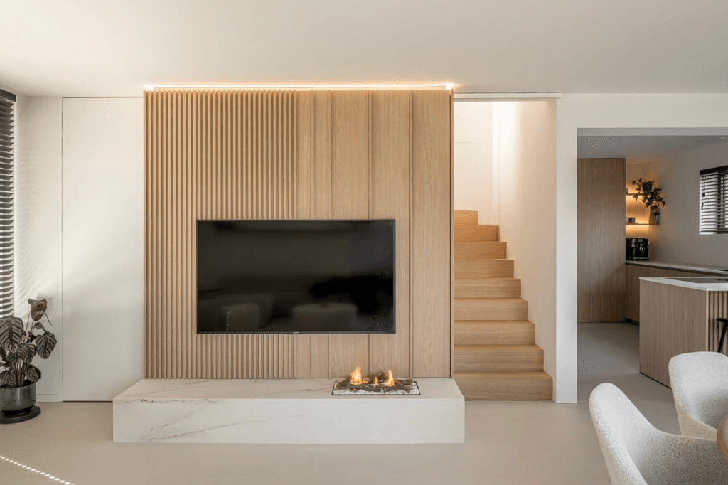 modern interieur met houten tv-wand en marmeren haard 