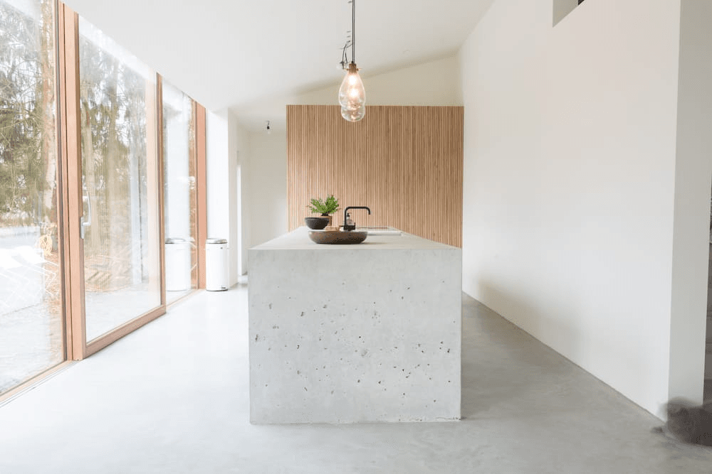 sober keuken interieur met betonnen eiland en grote glasramen